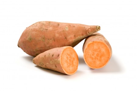 whole and halved sweet potatoes isolated on white